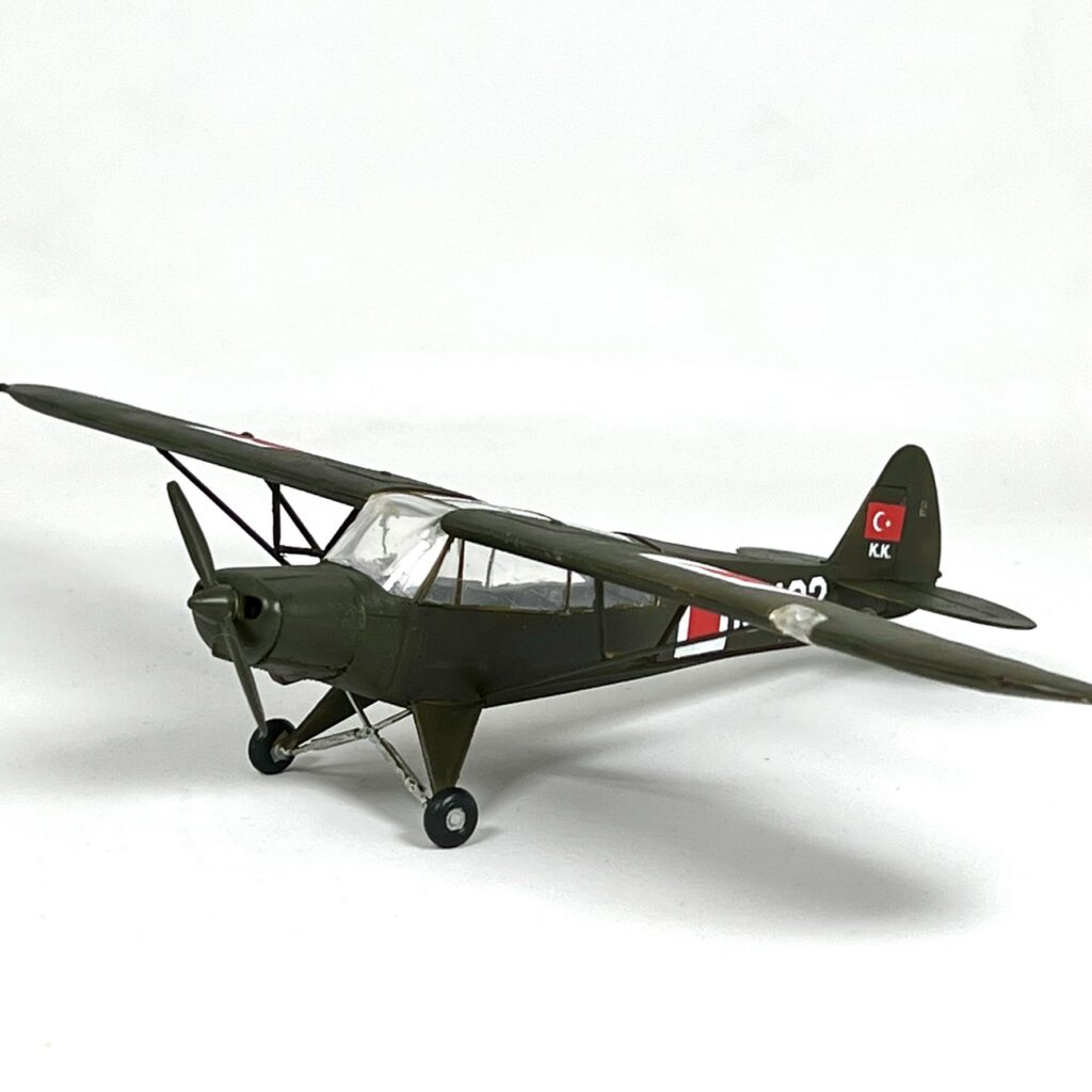 Kanat destekleri ve kuyruk tekerlekli iniş takımı görünen Piper L-21B maketinin yandan görünümü.