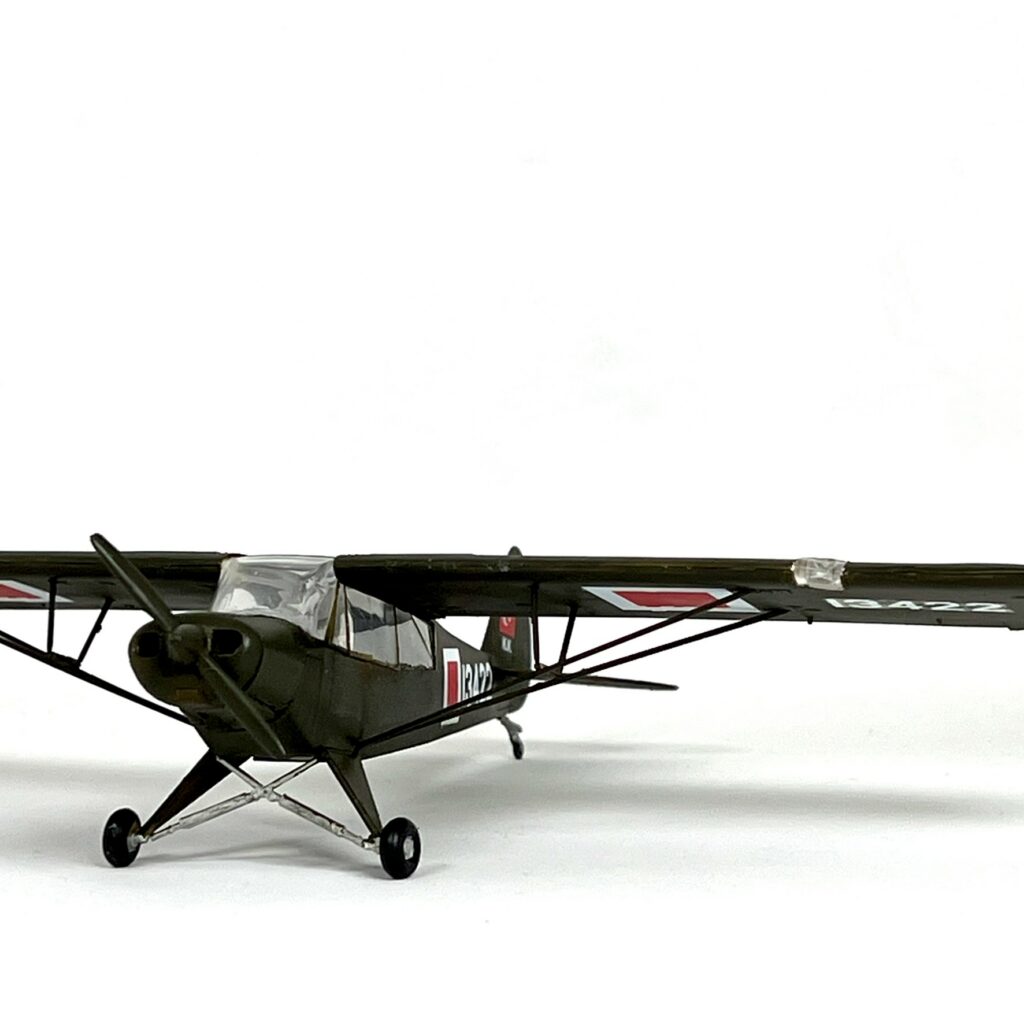 Yüksek kanadı ve iniş takımıyla tamamlanmış Piper L-21B maketinin önden görünümü.