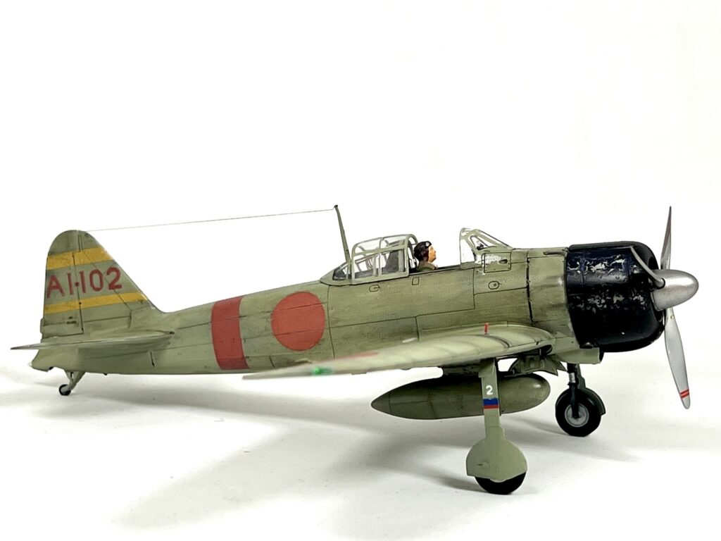 Finished Zero AI-102 with yellow tail stripes and a red fuselage band, side view